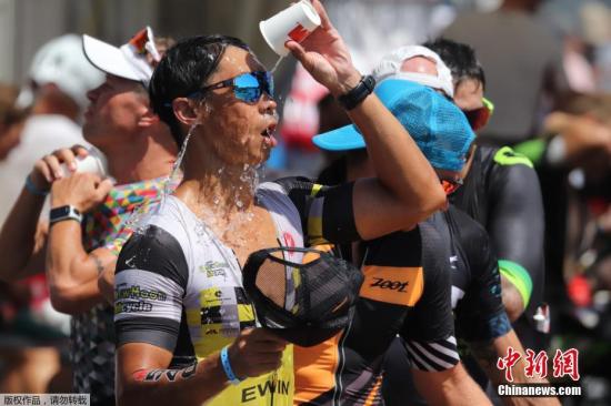 一向比较凉爽的德国也没有躲过这股热浪，多地都经历了历史同期以来的最高温度。图为在法兰克福举行的铁人三项比赛中，运动员用饮用水“冲凉”。