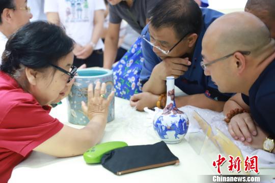 北京市文物鉴定委员会秘书长张如兰为市民鉴定收藏品。供图