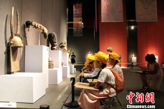 图为小学生们拿着画板在展览现场临摹艺术品?！≌韵?摄