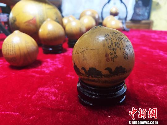 图为陈红在葫芦上刻的丝绸之路图之一。　高康迪 摄