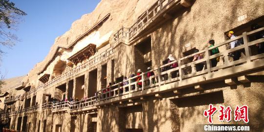 图为游客参观敦煌莫高窟?！∥航ň?摄