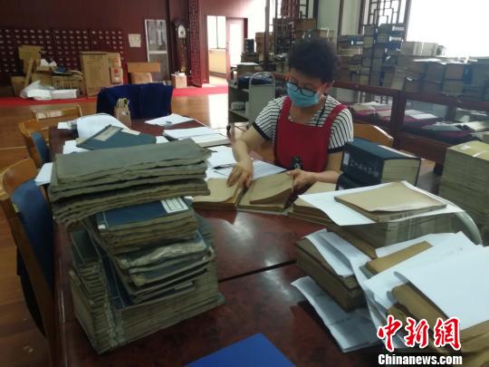 已经与古籍打交道20余年的工作人员贾秀丽，正在对近期已经编目的古籍做审校?！∷镦面?摄