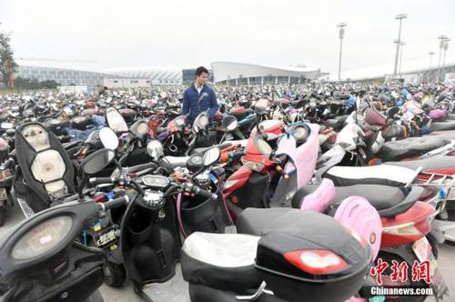 12月14日，福州仓山南二环附近的临时停车场停放超过2.2万辆无牌、超标电动车，场面震撼。福州市交警一个多月来共查处电动车各类交通违法14万多起，暂扣无牌、超标电动车2.2万多辆。图为市民凭有效证件及购车发票领回被扣车辆。<a target='_blank' href='http://www.chinanews.com/'>中新社</a>记者 吕明 摄