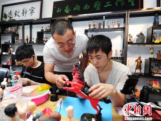 白春雨正在指导徒弟制作面塑 刘栋 摄 白春雨正在指导徒弟制作面塑 刘栋 摄