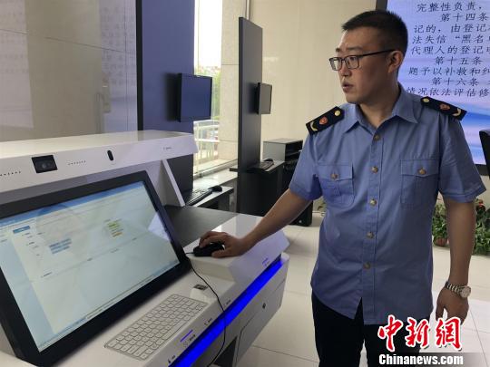 图为工作人员展示新的系统程序?！⊙钜?摄