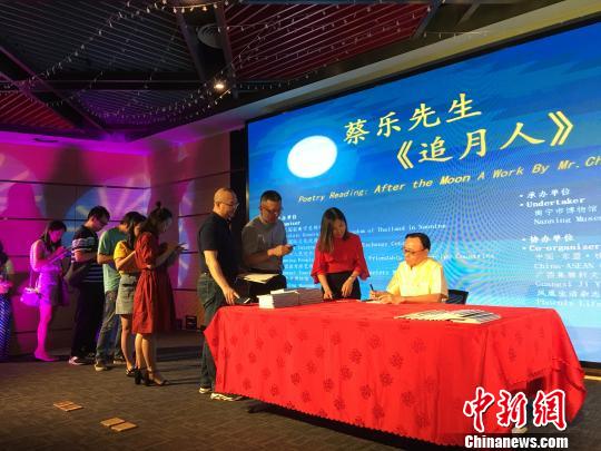 图为泰王国驻南宁总领事馆总领事蔡乐·蓬蒂窝拉卫为诗集《追月人》读者签字留念?！　〕虑锵?摄