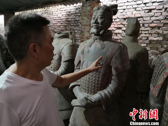 图为马石凹介绍兵马俑仿制品?！〉程镆?摄