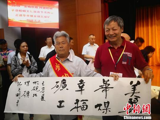 图为书画名家给华亭煤业集团公司全国劳模赠送作品。　魏建军 摄