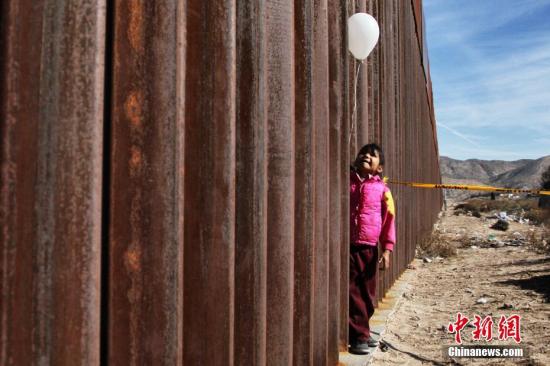 资料图:一名孩子在美墨隔离墙旁。 点击进入下一页