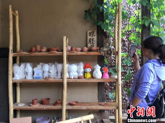 图为月牙泉小镇“敦煌彩陶”门口晾胚区吸引当地人拍照留念。　张婧 摄