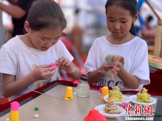 图为两个小女孩正在捏米塑?！∷镱?摄