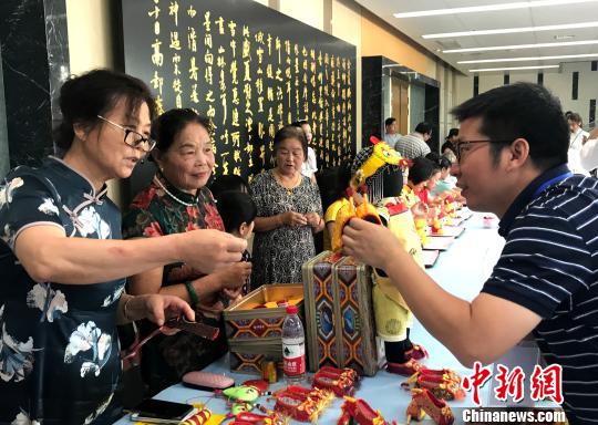 图为“秦观故里”高邮三垛七夕习俗“巧娘娘送巧”——心灵手巧的妇女将自己一针一线手工制作的虎鞋送给孩子?！〈藜衙?摄