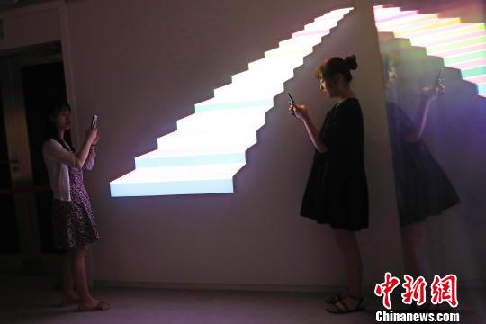 市民在艺术装置前合影留念。　殷立勤 摄