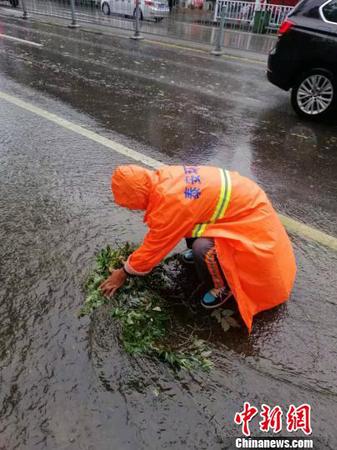 泰安环卫工人清理淤积，保持排水畅通。(泰安全媒体记者供图)