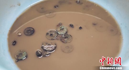 工作人员对古钱币进行清理?！⊙盍⒊?摄