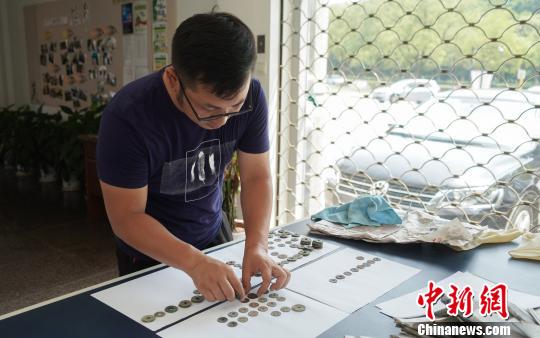 工作人员在研究古钱币“身份”?！⊙盍⒊?摄