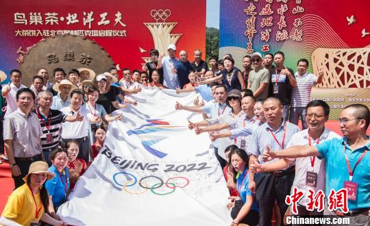 图为嘉宾在助威冬奥的条幅前合影留念。　夏波光 摄