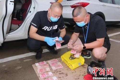 民警现场缴获现金31万元 竹溪县警方提供 民警现场缴获现金31万元 竹溪县警方提供