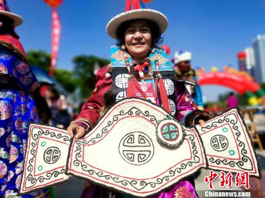 图为蒙古族“绣娘”展示作品马鞍垫?！±铞?摄