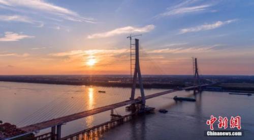 资料图：5月30日，随着最后一片钢箱梁吊装到位，长江经济带规划的重要过江通道——湖北嘉鱼长江公路大桥主桥顺利合龙。<a target='_blank' href='http://www.chinanews.com/'>中新社</a>记者 刘忠俊 摄