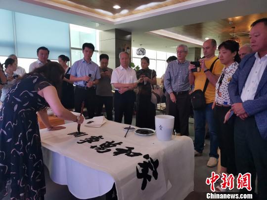 图为，庆祝新中国成立70周年外国专家座谈会暨驻济外国人才中秋节沙龙观上，外国专家观看书法表演?！∷锖觇?摄