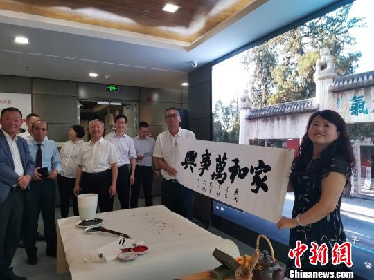 图为，庆祝新中国成立70周年外国专家座谈会暨驻济外国人才中秋节沙龙观上，外国专家展示获赠书法作品?！∷锖觇?摄