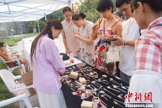 游客在首饰摊位前驻足?！≌澎匣?摄