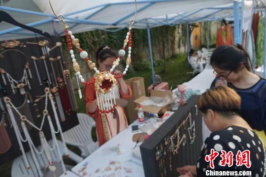 游客在首饰摊位前驻足?！≌澎匣?摄