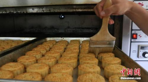 资料图：给定形月饼刷蛋液，保证月饼的色泽和口感。程鹏翔 摄