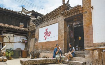 73岁的杨国保在位于云南省石屏县异龙镇符家营村的家中与放暑假的孙女聊天。新华社记者 江文耀摄