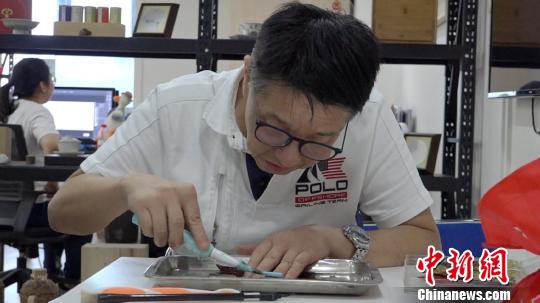 李亚非用电动牙刷正在制作叶雕作品?！⌒烀黝?摄