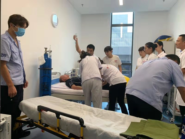 图为9月17日下午3时许，北京冬奥组委办公区“红十字救护站”医护人员、“红十字博爱救护队”队员协同赶来的急救车医务人员对患者进行有关检测和处理