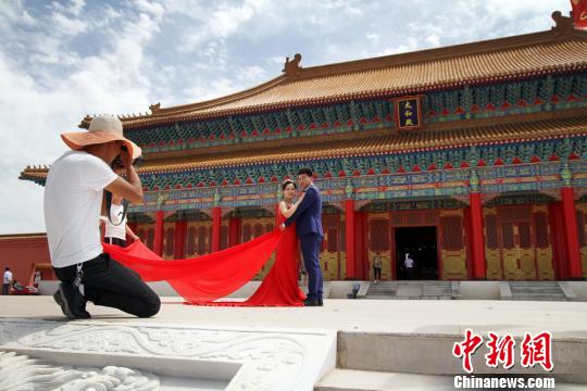 图为新人在兰州新区网红打卡地“长城影视城”拍结婚照?！《】?摄