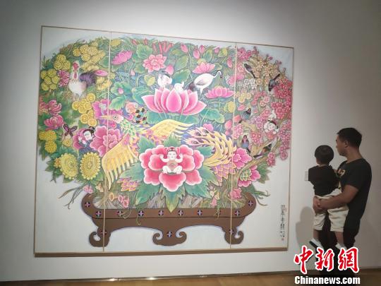 一位父亲带着孩子观看展览?！√菩∏?摄