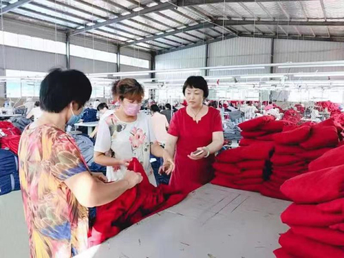 纵梅在扶贫车间里现场指导，解决贫困群众工作中的难题