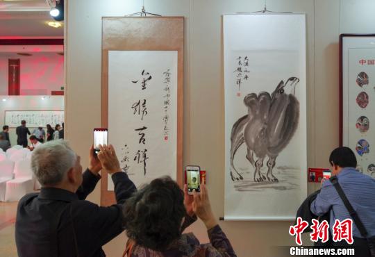 9日，观众在“庆祝中华人民共和国成立70周年——影视艺术家优秀书画作品展”上参观六小龄童的书法作品《金猴吉祥》和赵忠祥的画作《大漠之舟》?！?lt;a target='_blank' href='http://www.chinanews.com/'>中新社</a>记者 贾天勇 摄