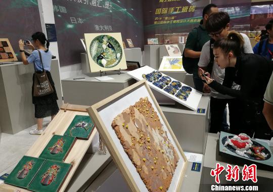 市民正在观看展出的手工瓷砖设计作品。　程景伟 摄