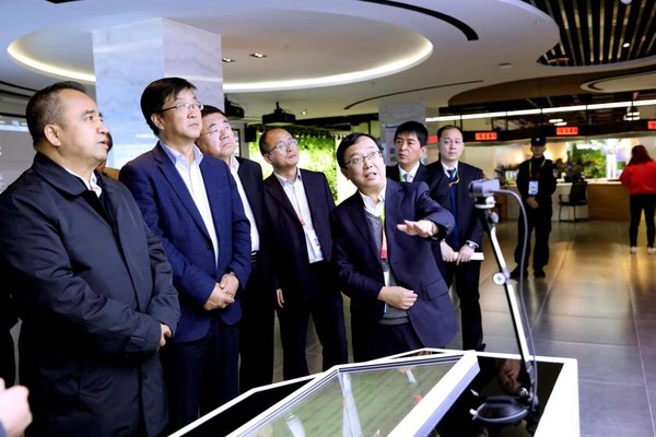 图为民盟中央农业委员会委员、杨凌示范区科技创新和转化推广局副局长、杨凌示范区科创中心（杨凌大学科技园）建设领导小组办公室常务副主任王博文（右一）向前来参观的新疆维吾尔自治区党委常委、副主席艾尔肯?吐尼亚孜一行介绍情况。