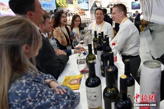 资料图：第二届进博会上，俄罗斯参展商向参观者推介俄罗斯红酒。<a target='_blank' href='http://www.chinanews.com/'>中新社</a>记者 毛建军 摄