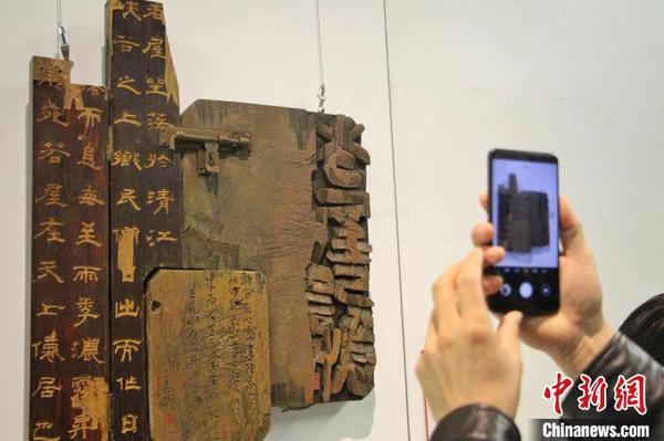 图为观众在刻字作品前驻足拍照。　赵晓 摄