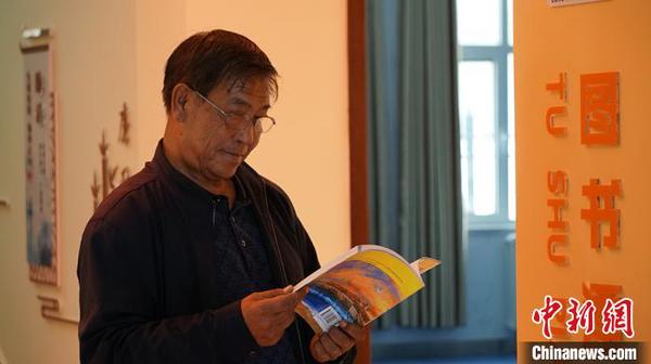 图为社区居民在图书漂流站看书?！∥航ň?摄