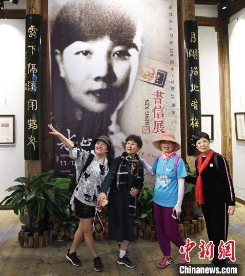 观众在展出的冰心青年时期黑白老照片前合影。　记者刘可耕 摄