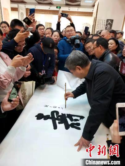 山东省书法家协会主席顾亚龙在现场展示书法?！∏锔?摄