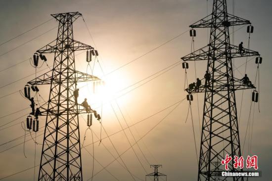 资料图：电力工人在高空工作。毛强 摄