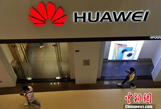 资料图：市民从华为产品专卖店旁经过。 <a target='_blank' href='http://www.chinanews.com/'>中新社</a>记者 张斌 摄