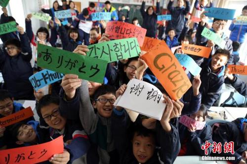 资料图：中学生们用八国语言书写“谢谢”。周小云 摄