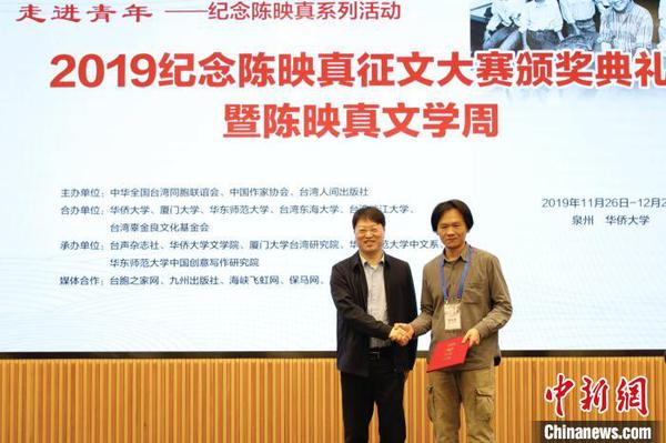 中华全国台湾同胞联谊会副会长郑平(左)为“陈映真思想与创作”论文一等奖获得者张立本颁奖。　刘沛 摄