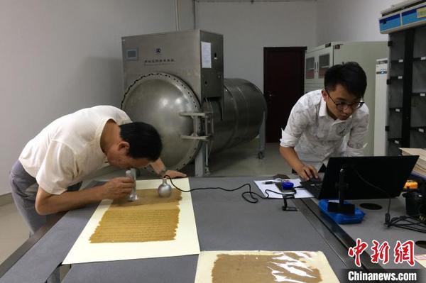 技术人员对“圣旨”原件进行分析采样。(资料图) 钟欣 摄