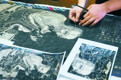 工作人员正在进行西藏罗汉拓片修复 点击进入下一页