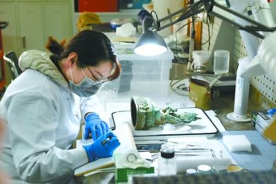 修复师在为鎏金金刚勇识菩萨取样记录 点击进入下一页